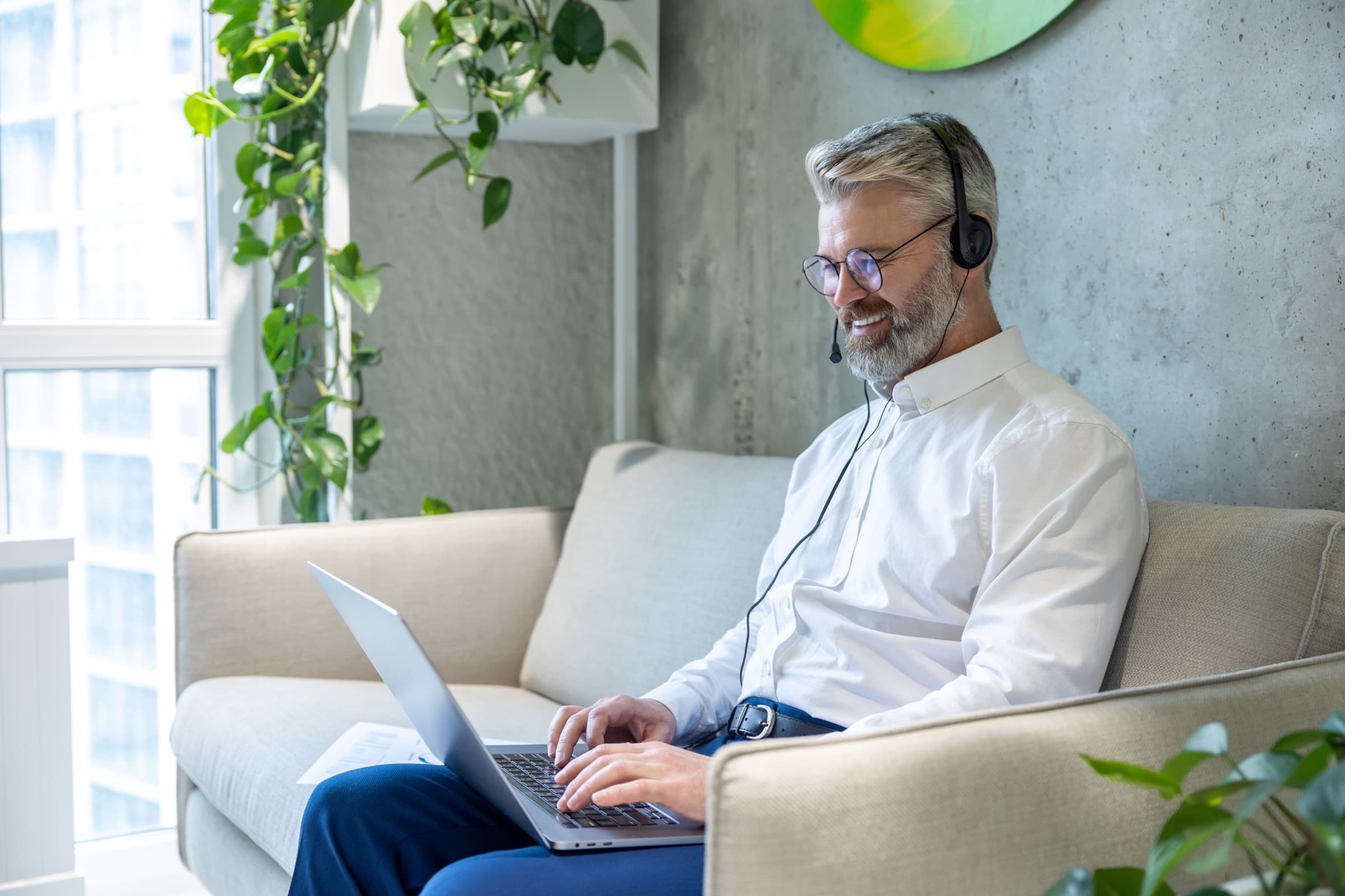 A founder working with a headset and laptop, replying to customers.